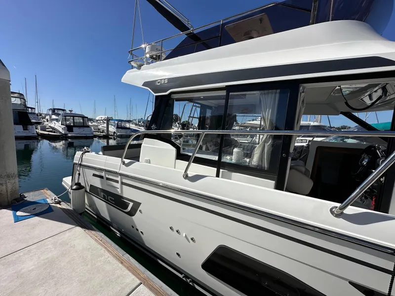 Slide: The Image of 2021 Jeanneau NC 1095 Fly yacht docked at marina under clear blue sky. - 6