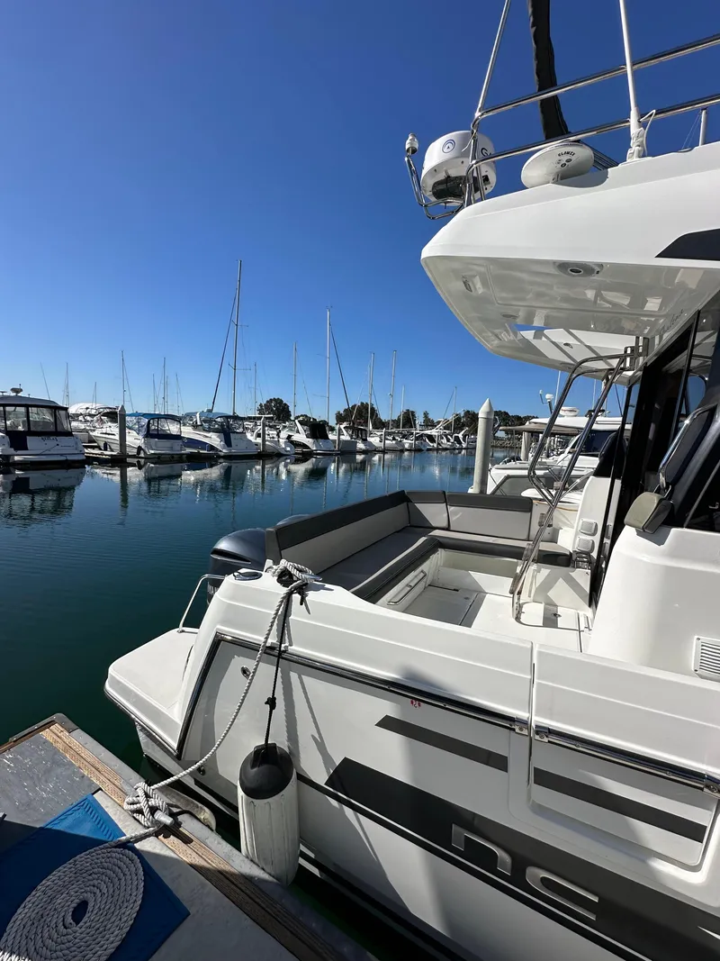 Slide: The Image of 2021 Jeanneau NC 1095 Fly docked at marina, clear blue sky, calm water. - 7