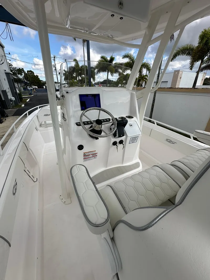 Slide: The Image of 2025 Glasstream 28 Pro boat interior with steering wheel and seating, palm trees in background. - 11