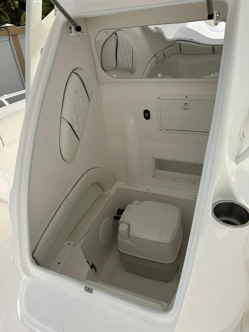 Slide: The Image of 2025 Glasstream 28 Pro boat interior with compact toilet and storage. - 16