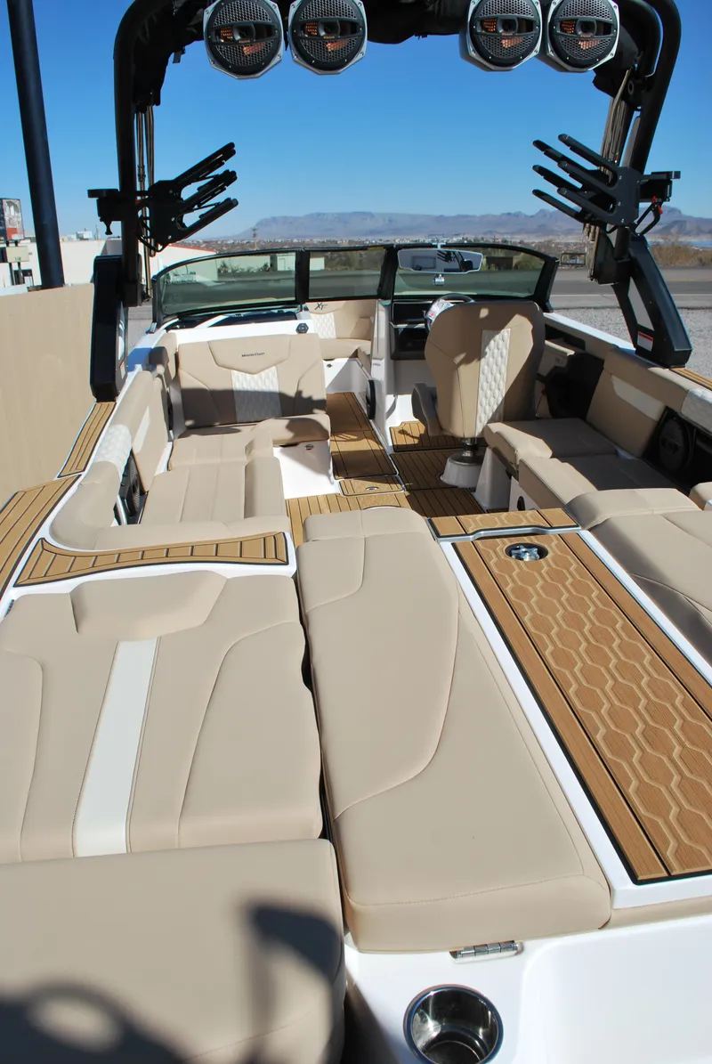 Slide: The Image of 2025 MasterCraft XT25 boat interior with beige seating and modern design. - 12