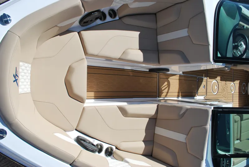 Slide: The Image of 2025 MasterCraft XT25 boat interior with beige seating and wood accents. - 4