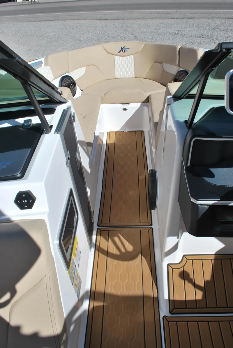 Slide: The Image of 2025 MasterCraft XT25 boat interior with teak flooring and beige seating. - 6