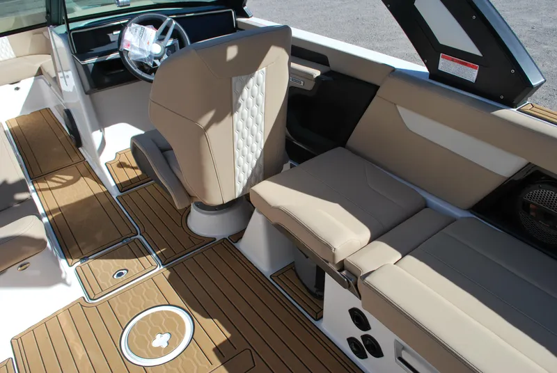 Slide: The Image of 2025 MasterCraft XT25 boat interior with tan seating and wood-style flooring. - 9