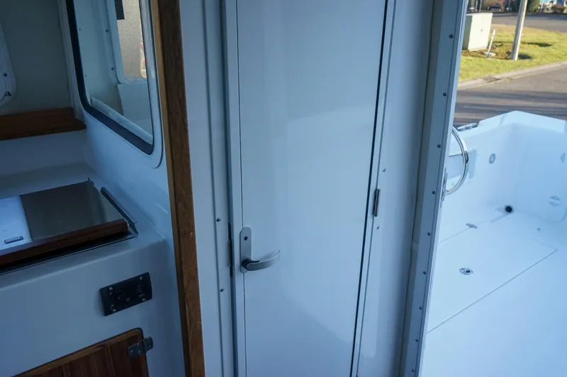 Slide: The Image of 2025 C-Dory 25' Tomcat Catamaran interior, featuring sleek white surfaces and modern design. - 11