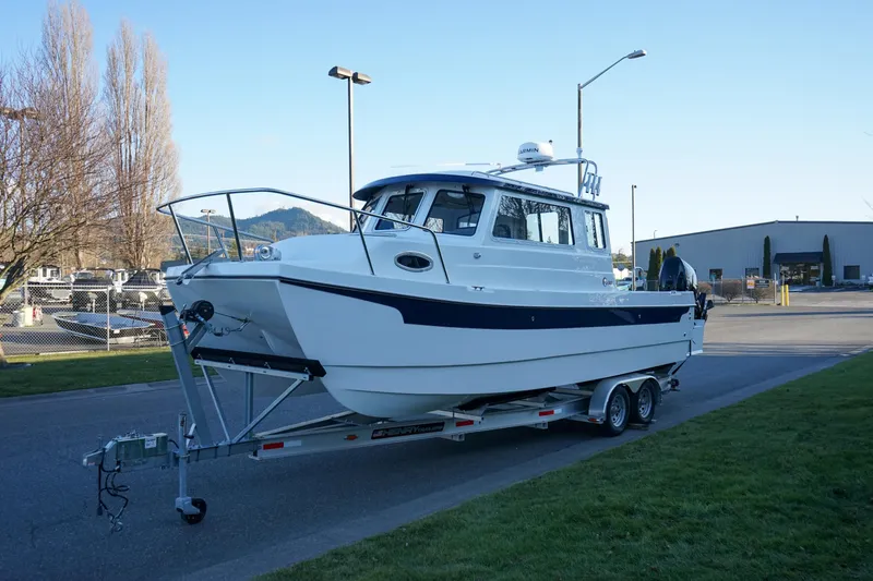 Slide: The Image of 2025 C-Dory 25' Tomcat Catamaran on trailer, parked outdoors. - 18