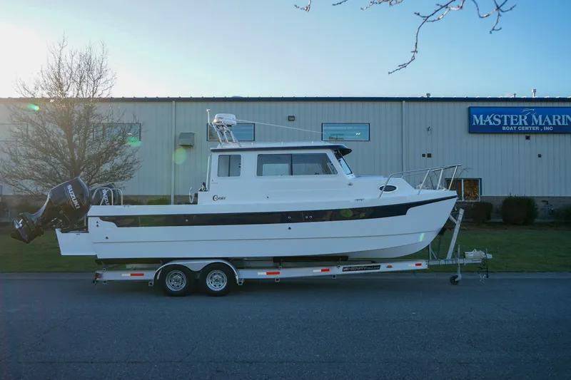 Slide: The Image of 2025 C-Dory 25' Tomcat Catamaran on trailer outside Master Marine Boat Center. - 2