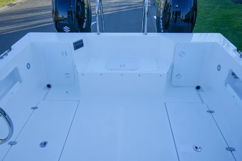 Slide: The Image of 2025 C-Dory 25' Tomcat Catamaran deck with storage compartments and dual engines. - 6