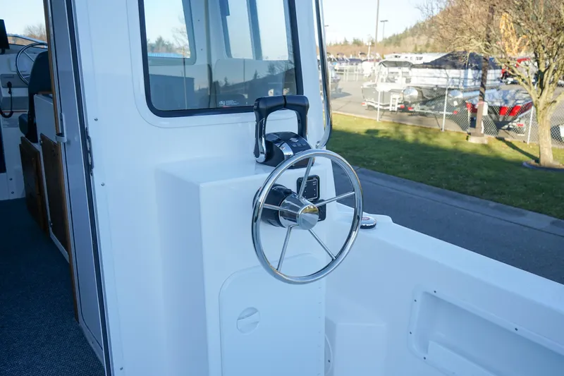 Slide: The Image of 2025 C-Dory 25' Tomcat Catamaran steering wheel and cockpit view. - 7