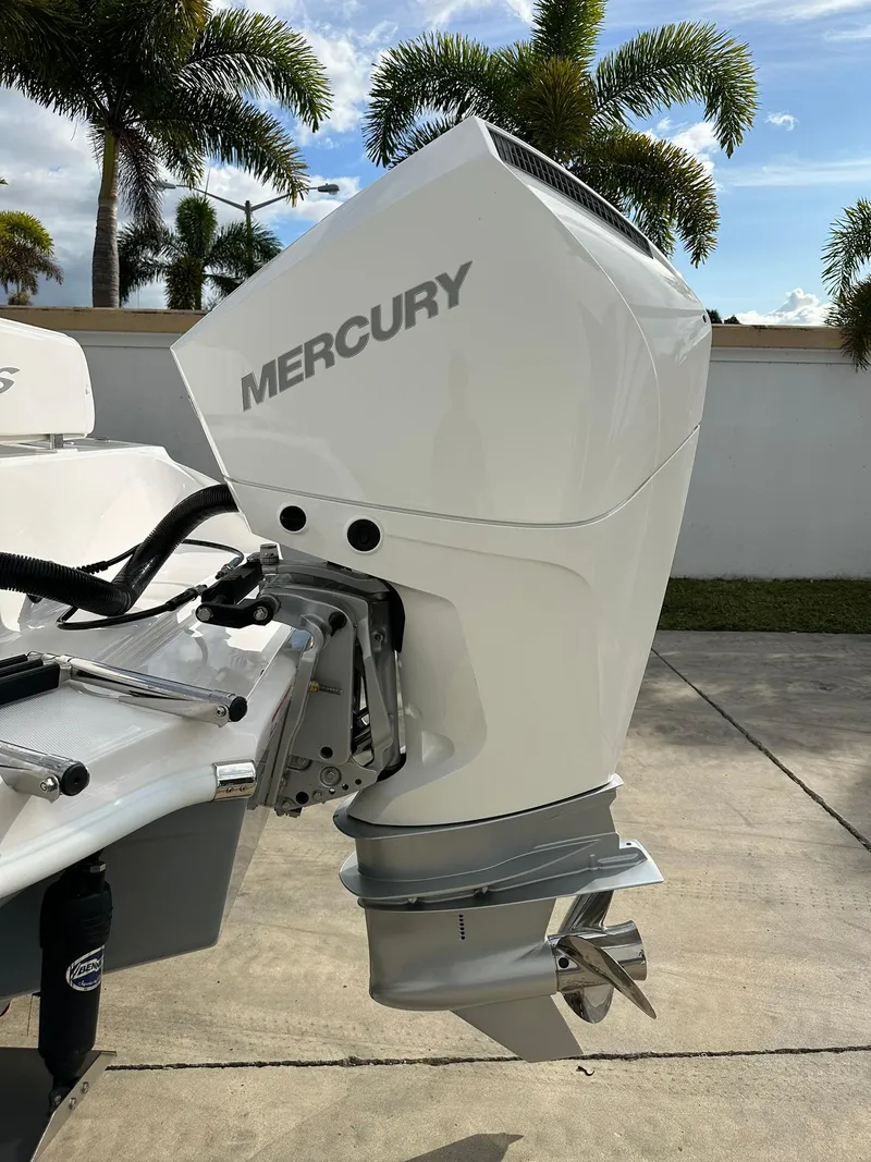 Slide: The Image of 2025 Glasstream 240 CCX with Mercury outboard motor, parked outdoors. - 9