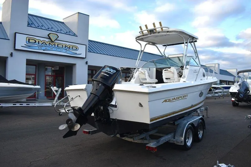 Slide: The Image of 2001 Aquasport 215 Explorer Walk-around boat on trailer at dealership. - 10