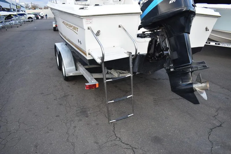 Slide: The Image of 2001 Aquasport 215 Explorer Walk-around boat on trailer with outboard motor and ladder. - 13