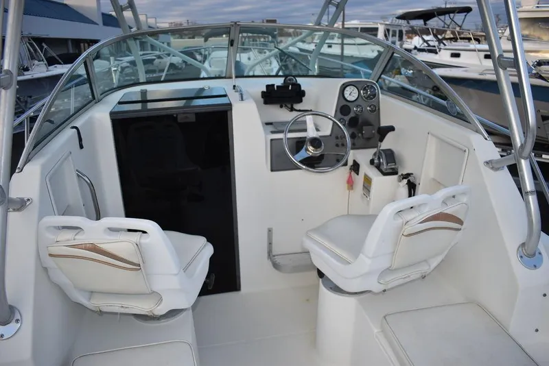 Slide: The Image of 2001 Aquasport 215 Explorer Walk-around boat interior with steering wheel and seating. - 28