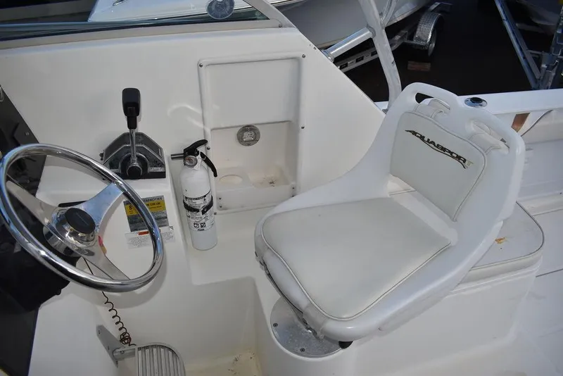Slide: The Image of 2001 Aquasport 215 Explorer Walk-around boat cockpit with steering wheel and seat. - 29