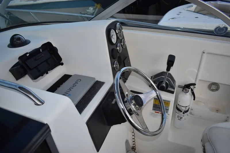 Slide: The Image of 2001 Aquasport 215 Explorer Walk-around boat cockpit with steering wheel and controls. - 30