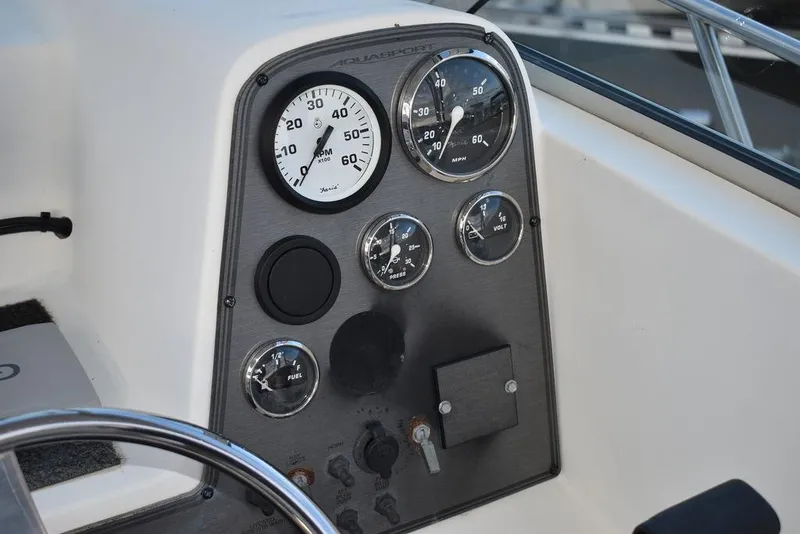 Slide: The Image of Dashboard of 2001 Aquasport 215 Explorer Walk-around boat with gauges and controls. - 31