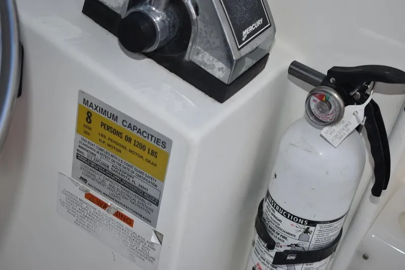 Slide: The Image of 2001 Aquasport 215 Explorer Walk-around boat capacity label and fire extinguisher. - 32