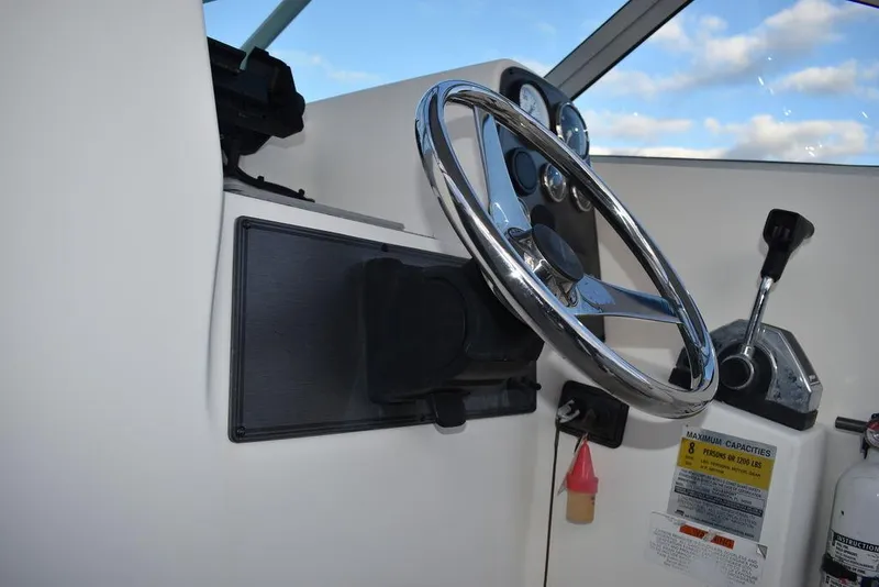 Slide: The Image of 2001 Aquasport 215 Explorer Walk-around helm with steering wheel and controls. - 34