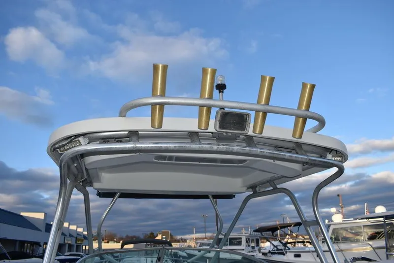 Slide: The Image of T-top of 2001 Aquasport 215 Explorer Walk-around with rod holders, under a blue sky. - 36