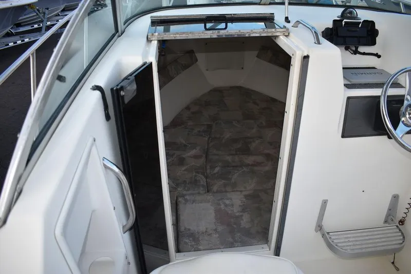 Slide: The Image of 2001 Aquasport 215 Explorer Walk-around cabin interior with open door and steering area. - 37