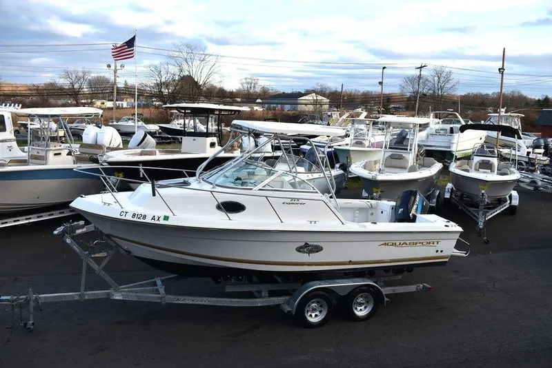 Slide: The Image of 2001 Aquasport 215 Explorer Walk-around boat on trailer in marina setting. - 4
