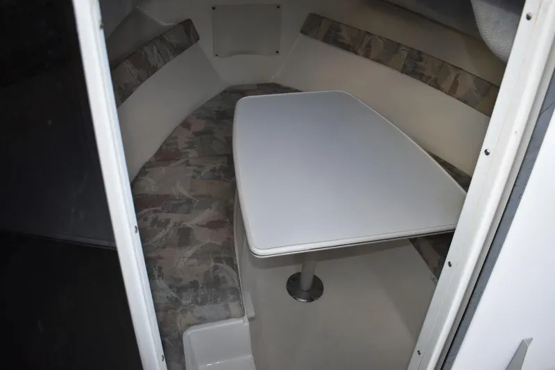 Slide: The Image of 2001 Aquasport 215 Explorer Walk-around cabin interior with table and seating. - 46