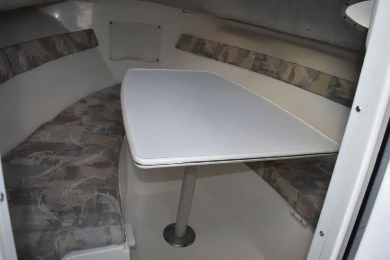 Slide: The Image of 2001 Aquasport 215 Explorer Walk-around cabin interior with seating and table. - 47