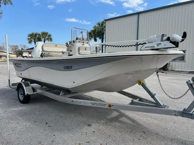 Slide: The Image of 2023 Carolina Skiff 19 LS boat on trailer, parked outdoors near a building. - 1