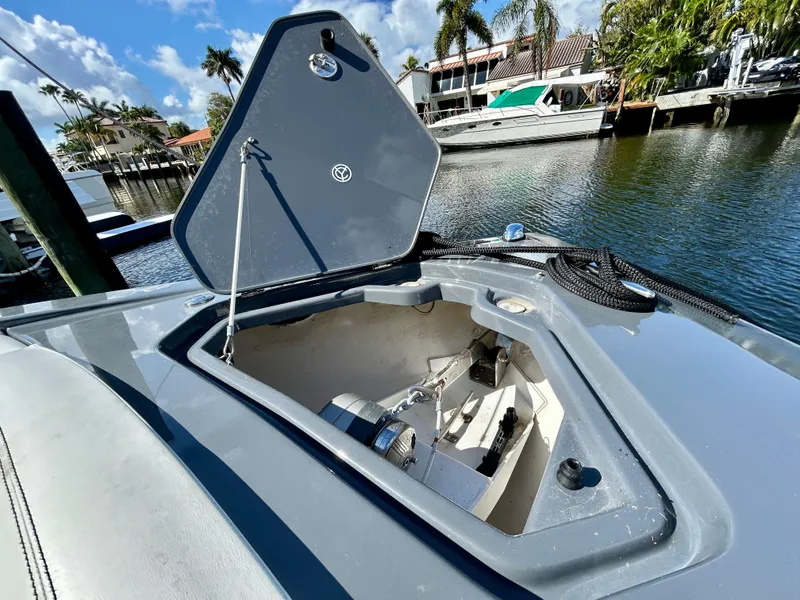 Slide: The Image of 2021 Cruisers Yachts 338 South Beach Edition Bow Rider anchor compartment open by waterfront. - 12