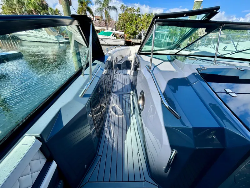 Slide: The Image of 2021 Cruisers Yachts 338 South Beach Edition Bow Rider, sleek design, docked by palm trees. - 17