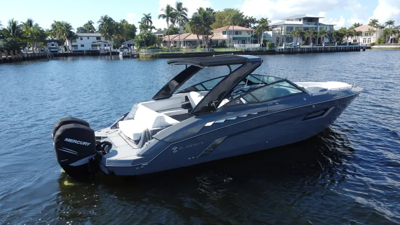 Slide: The Image of 2021 Cruisers Yachts 338 South Beach Edition Bow Rider on calm water, surrounded by palm trees. - 3