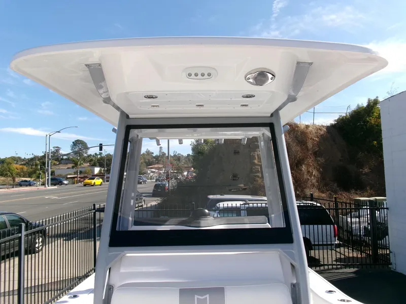 Slide: The Image of 2025 Sea Fox 228 Commander boat with T-top, parked outdoors on a sunny day. - 13