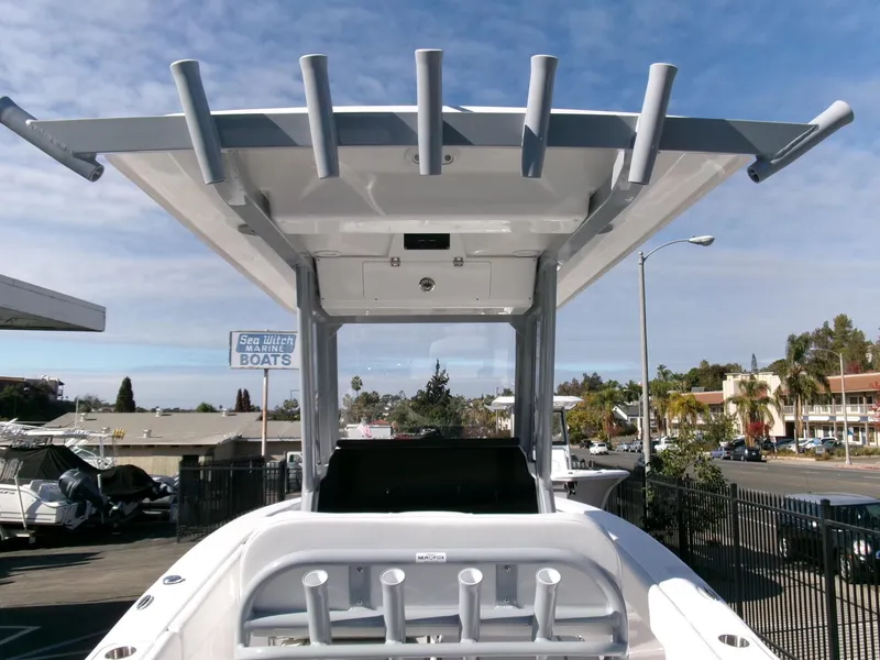 Slide: The Image of 2025 Sea Fox 228 Commander boat with T-top and rod holders, parked outdoors. - 23