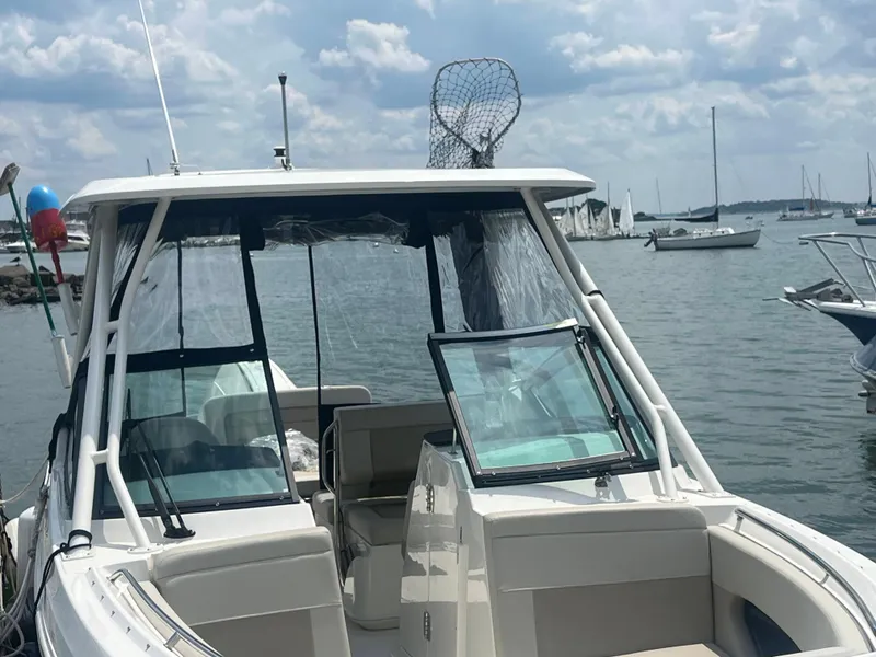 Slide: The Image of 2023 Boston Whaler 240 Vantage boat docked on a calm, cloudy day. - 1