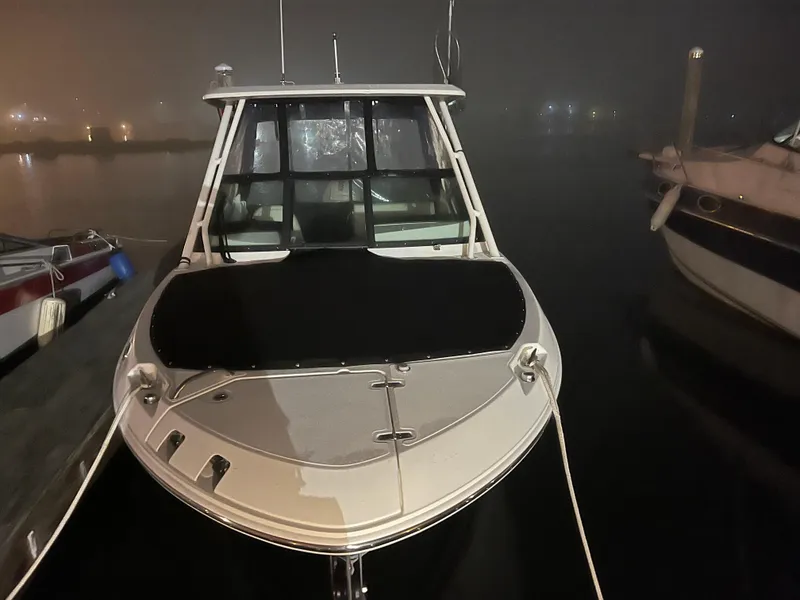 Slide: The Image of 2023 Boston Whaler 240 Vantage boat docked at night in a foggy marina. - 6