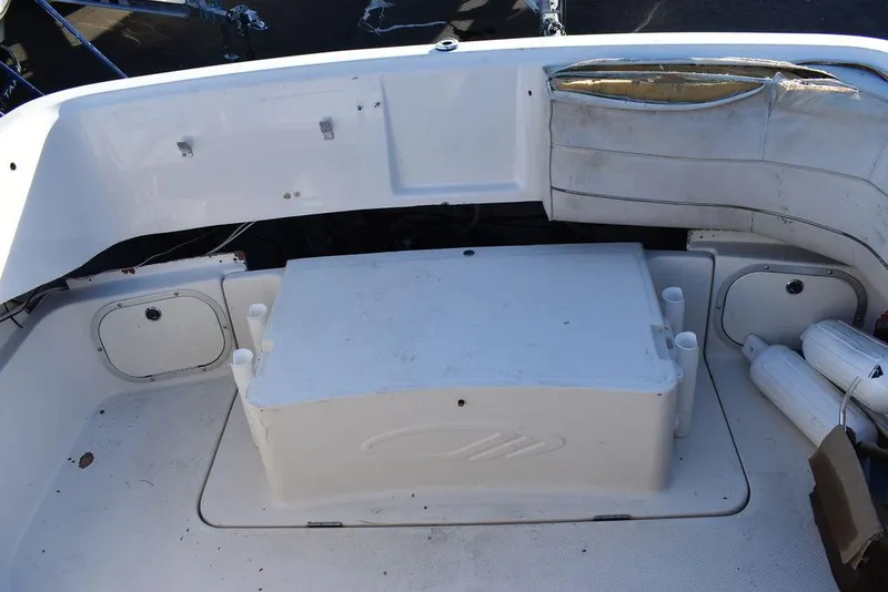 Slide: The Image of 1999 Maxum 2300SC boat interior with white seating and storage compartments. - 15