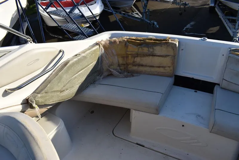 Slide: The Image of 1999 Maxum 2300SC boat interior with damaged seating and exposed foam. - 18