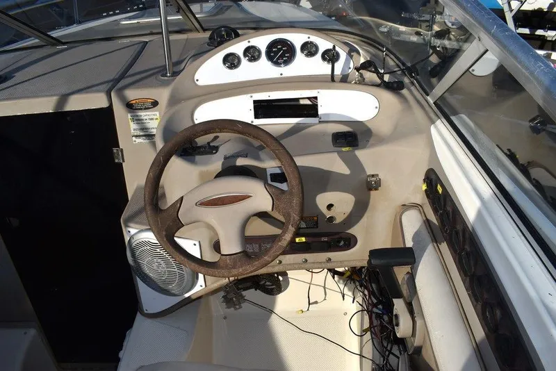 Slide: The Image of 1999 Maxum 2300SC boat dashboard with steering wheel and control panel. - 22