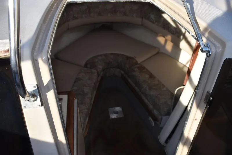 Slide: The Image of 1999 Maxum 2300SC boat cabin interior with cushioned seating and compact design. - 24