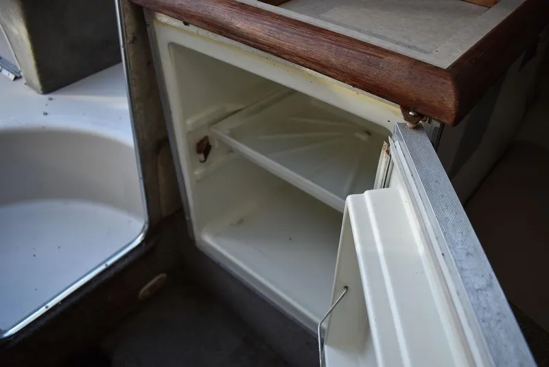 Slide: The Image of 1999 Maxum 2300SC boat interior with open storage compartment. - 27