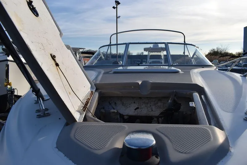 Slide: The Image of 1999 Maxum 2300SC boat with open engine compartment, docked under a clear sky. - 29