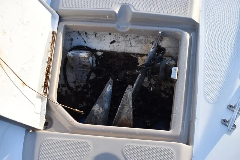 Slide: The Image of Anchor storage compartment on a 1999 Maxum 2300SC boat, showing anchors and ropes. - 30