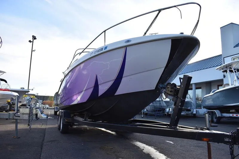 Slide: The Image of 1999 Maxum 2300SC boat on trailer with purple graphics, parked outdoors. - 33