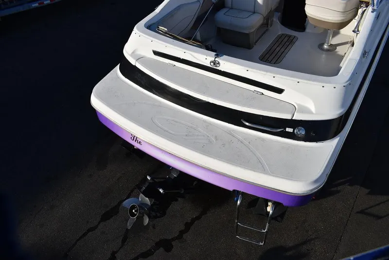 Slide: The Image of 1999 Maxum 2300SC boat stern with purple trim and outboard motor. - 9