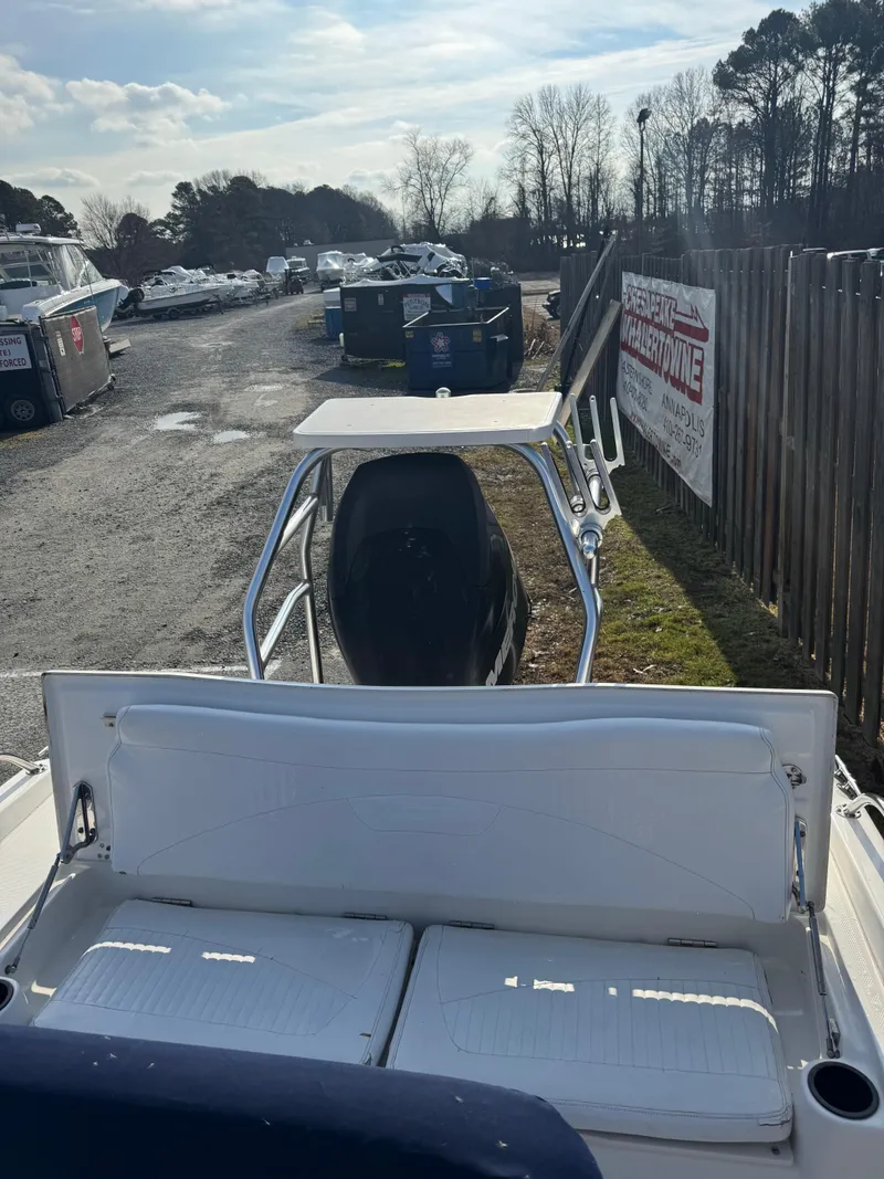Slide: The Image of 2009 Boston Whaler 180 Dauntless boat parked outdoors near a fence and storage area. - 3