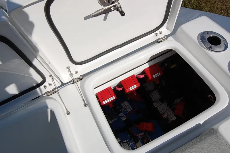 Slide: The Image of 2025 Cape Horn 28XS boat storage compartment with red battery switches and wiring. - 10
