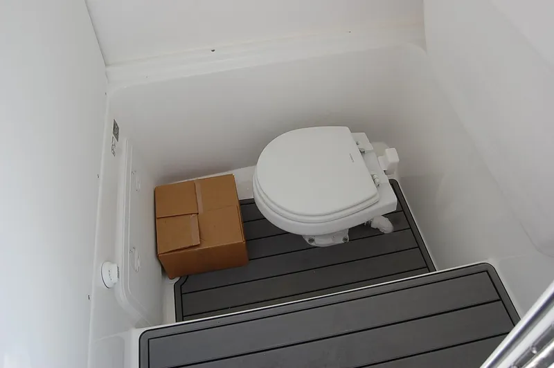 Slide: The Image of 2025 Cape Horn 28XS boat interior with toilet and box on gray flooring. - 17