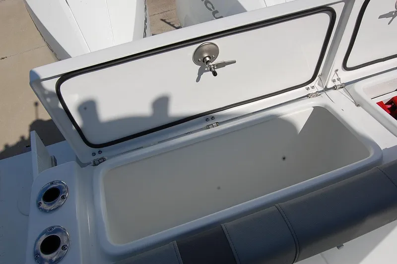Slide: The Image of 2025 Cape Horn 28XS boat storage compartment with open lid and secure latch. - 8