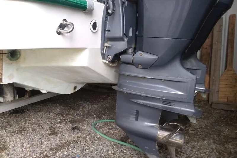 Slide: The Image of 1996 Mako 262 Center Console boat with outboard motor, parked on gravel. - 12