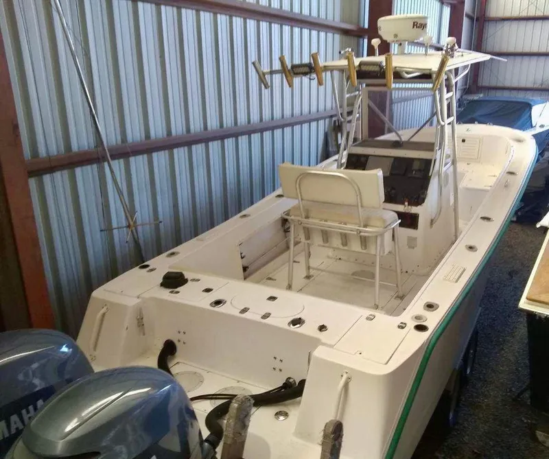 Slide: The Image of 1996 Mako 262 Center Console boat in storage, featuring dual Yamaha engines. - 2